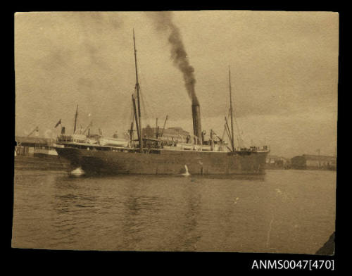 An unladen cargo passenger steamship manoeuvering into a new berth