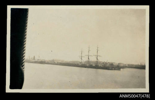 Ships loading or unloading cargo at a long wharf