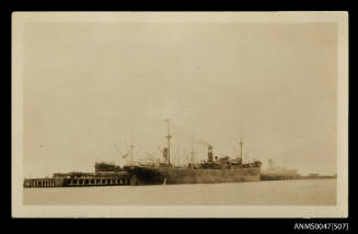 Distant view of three cargo ships loading / unloading cargo