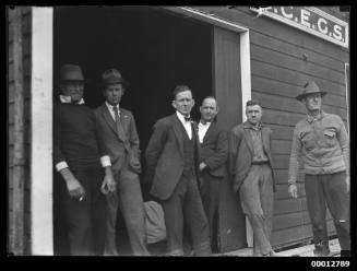 Six men standing outside SCEGS boatshed, Berry's Bay