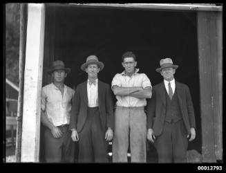 Four men standing outside the SCEGS boat shed in Berry's Bay on Sydney Harbour