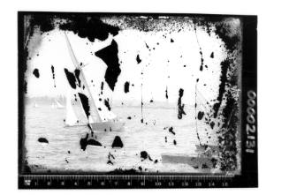 A badly damaged glass plate negative of a cutter, two row boats and other sailing boats on Sydney Harbour