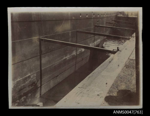 Part of metal hull of unidentified ship in dry dock