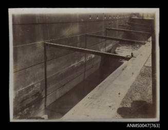 Part of metal hull of unidentified ship in dry dock