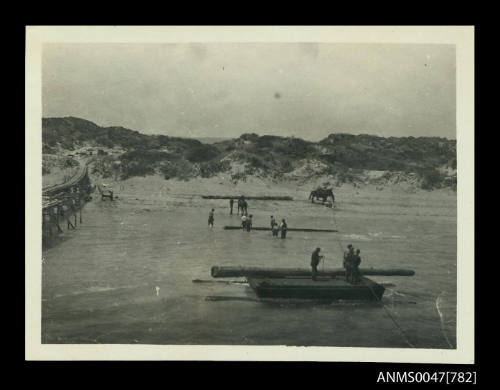 Jetty under construction with sand dunes in background