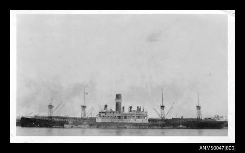 Port side view of an unidentified cargo/ passenger ship berthed at a wharf