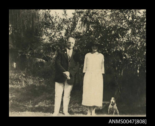 Man, woman and dog standing in a garden
