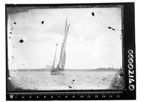 A  yawl or possibly a cutter on Sydney Harbour with a three masted ship visible in the background