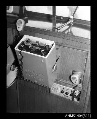 Photographic negative showing two AWA brand marine communications devices on board a boat