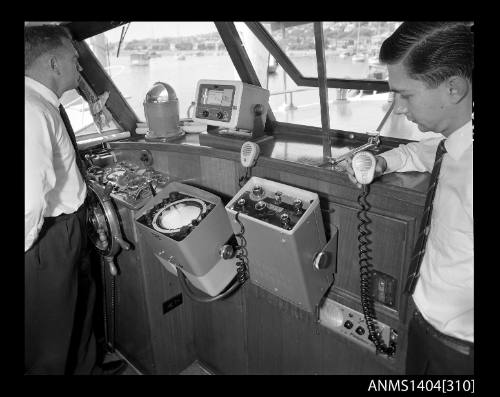 Photographic negative showing a man demonstrating an AWA brand Pilotphone III marine radio on board a boat