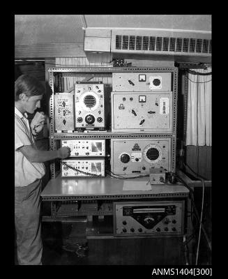 Photographic negative showing a man operating communications equipment on a boat