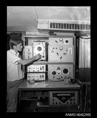 Photographic negative showing a man operating communications equipment on a boat
