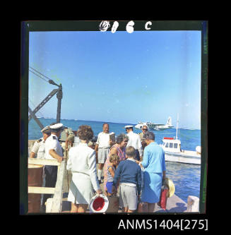 Photographic transparency showing passengers on a jetty and the Ansett Airways flying boat Beachcomber at Lord Howe Island