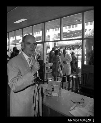 Photographic negative showing a man using the loud speaker system at Circular Quay Overseas Passenger Terminal