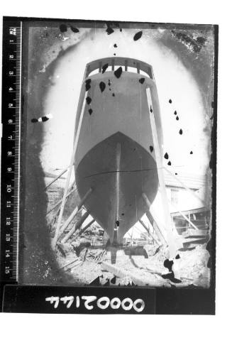 View taken from ground looking up towards the supported hull of a yet to be completed boat