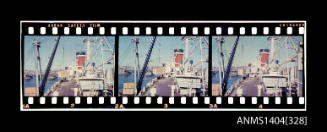 Photographic slide film showing wooden crates being loaded onto a Blue Star Line ship with Glebe Island Bridge in background