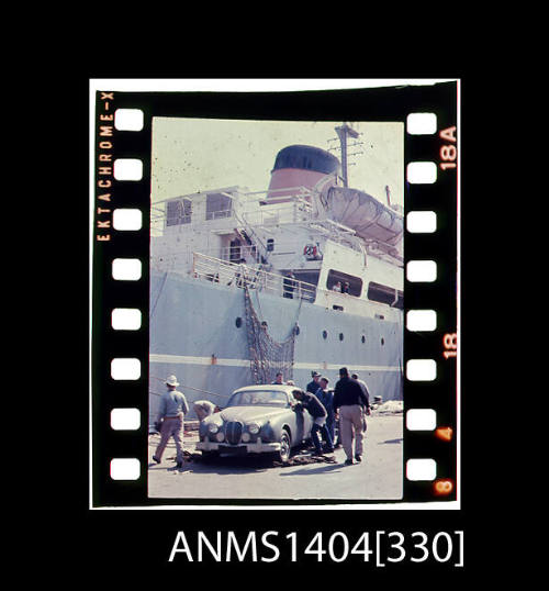 Photographic slide film showing a Jaguar car about to be loaded onto a cargo vessel