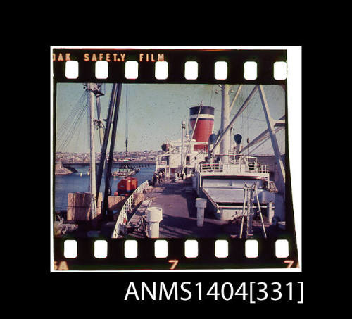 Photographic slide film showing wooden crates about to be loaded onto a Blue Star Line ship with Glebe Island Bridge in background