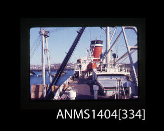 Photographic slide showing wooden crates about to be loaded onto a Blue Star Line ship with Glebe Island Bridge in background