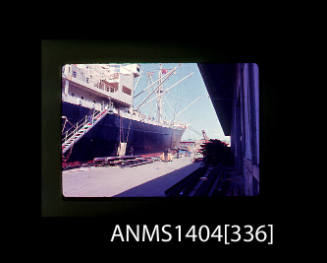 Photographic slide showing building materials being loaded onto a vessel with Glebe Island Bridge in the background