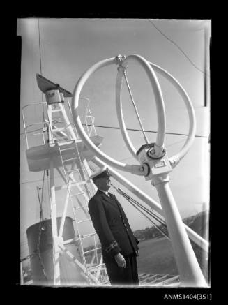Photographic negative showing an officer with communications aerials and equipment on top of a ship