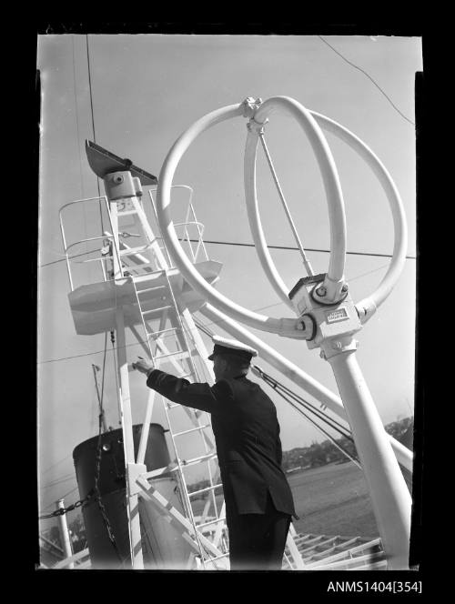 Photographic negative showing an officer with communications aerials and equipment on top of a ship