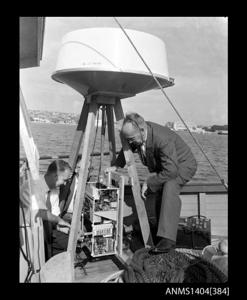 Photographic negative showing radar being installed on the deck of a boat