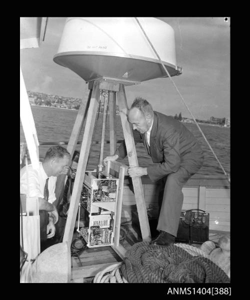 Photographic negative showing radar being installed on the deck of a boat