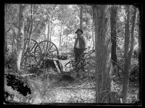 Portrait of a man standing next to an overturned carriage