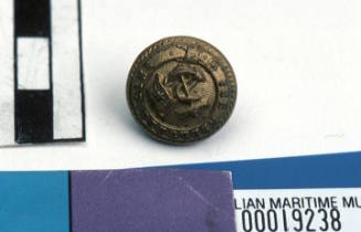 Aberdeen White Star Line small round brass button with gilt on front with raised relief pattern of fouled anchor with flag pole and flag with single star and line through middle