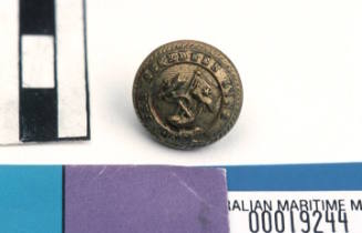 Aberdeen White Star Line small round brass button with gilt on front with raised relief pattern of fouled anchor with flag pole and flag with single star and line through middle