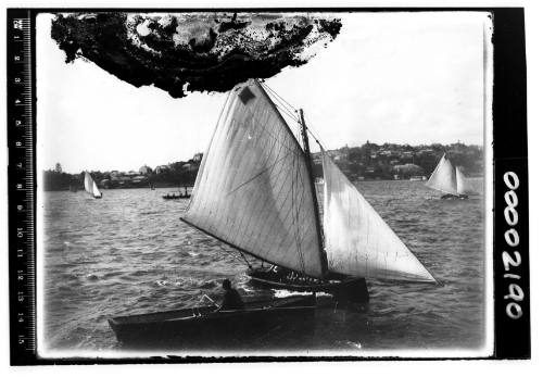 Glass plate negative image of a row boat and what is possibly a 14 footer on Sydney Harbour