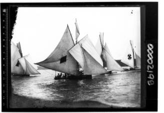Four 22-24 footers on Sydney Harbour. Boat center left has triangle on the mainsail, the boat in the centre a diamond and the boat on the far right displaying a maltese cross is Mark Foy's catamaran FLYING FISH.