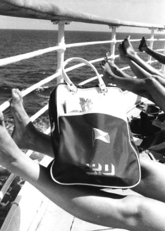 Photograph depicting the legs of some people sunbathing and a P&O bag