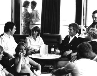 Photograph depicting a group of people at a ship's bar having some cocktails