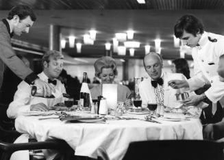 Photograph depicting a group of people being served dinner