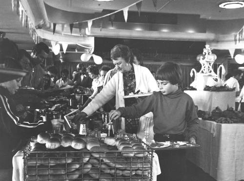 Photograph depicting a group of people serving thmeselves from a buffet