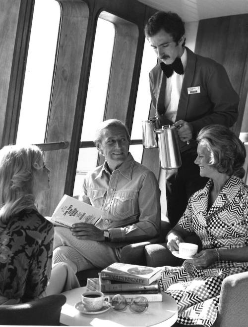 Photograph depicting a group of people being served tea and coffee