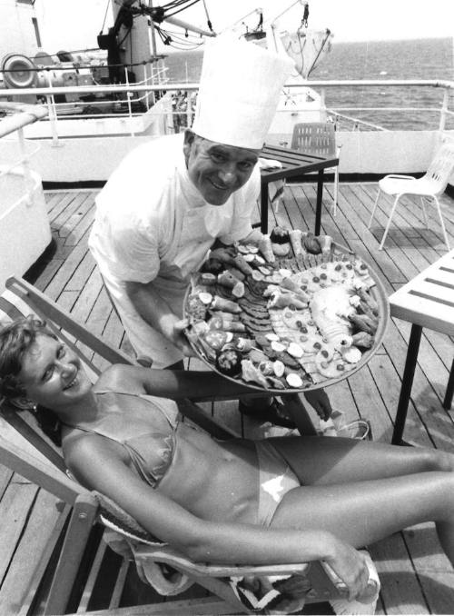 Photograph depicting a chef with a food platter and a woman