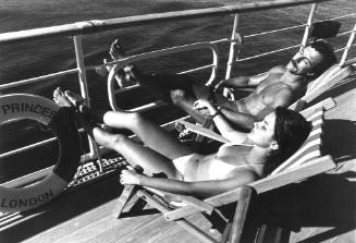 Photograph depicting a couple sunbathing on deck