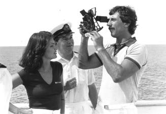 Photograph depicting a man using a sextant