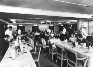 Photograph depicting a group of people at a ship's restaurant
