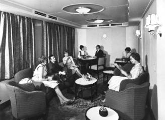 Photograph depicting a group of people in a ship's sitting room