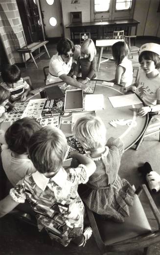 Photograph depicting a group of children playing board games