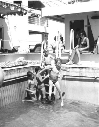 Photograph depicting four children playing at the ship's pool