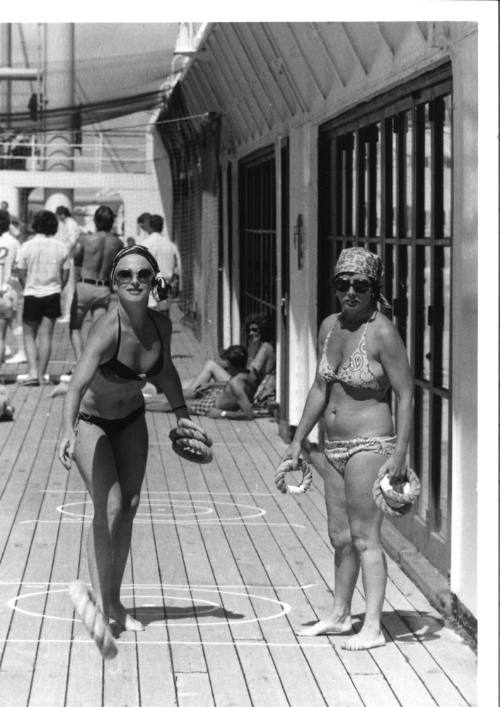 Photograph depicting two women playing deck quoits