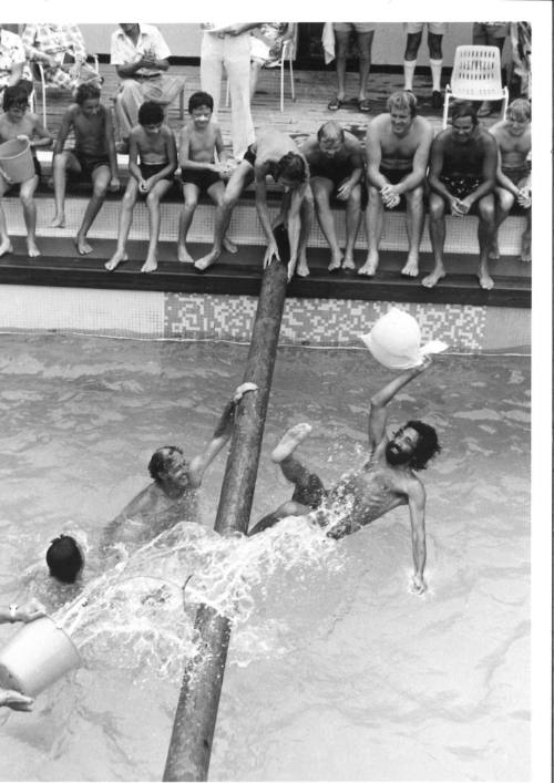 Photograph depicting a group of men playing greasy pole