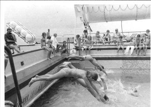 Photograph depicting a group of children diving into a pool