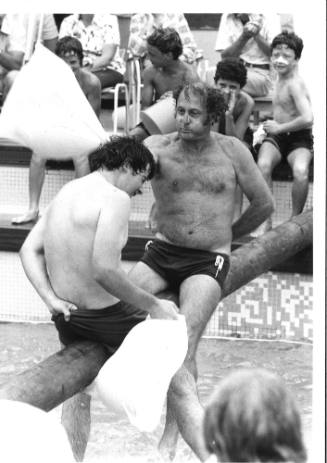 Photograph depicting two men playing greasy pole