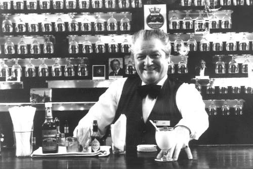 Photograph depicting a bartender serving a drink